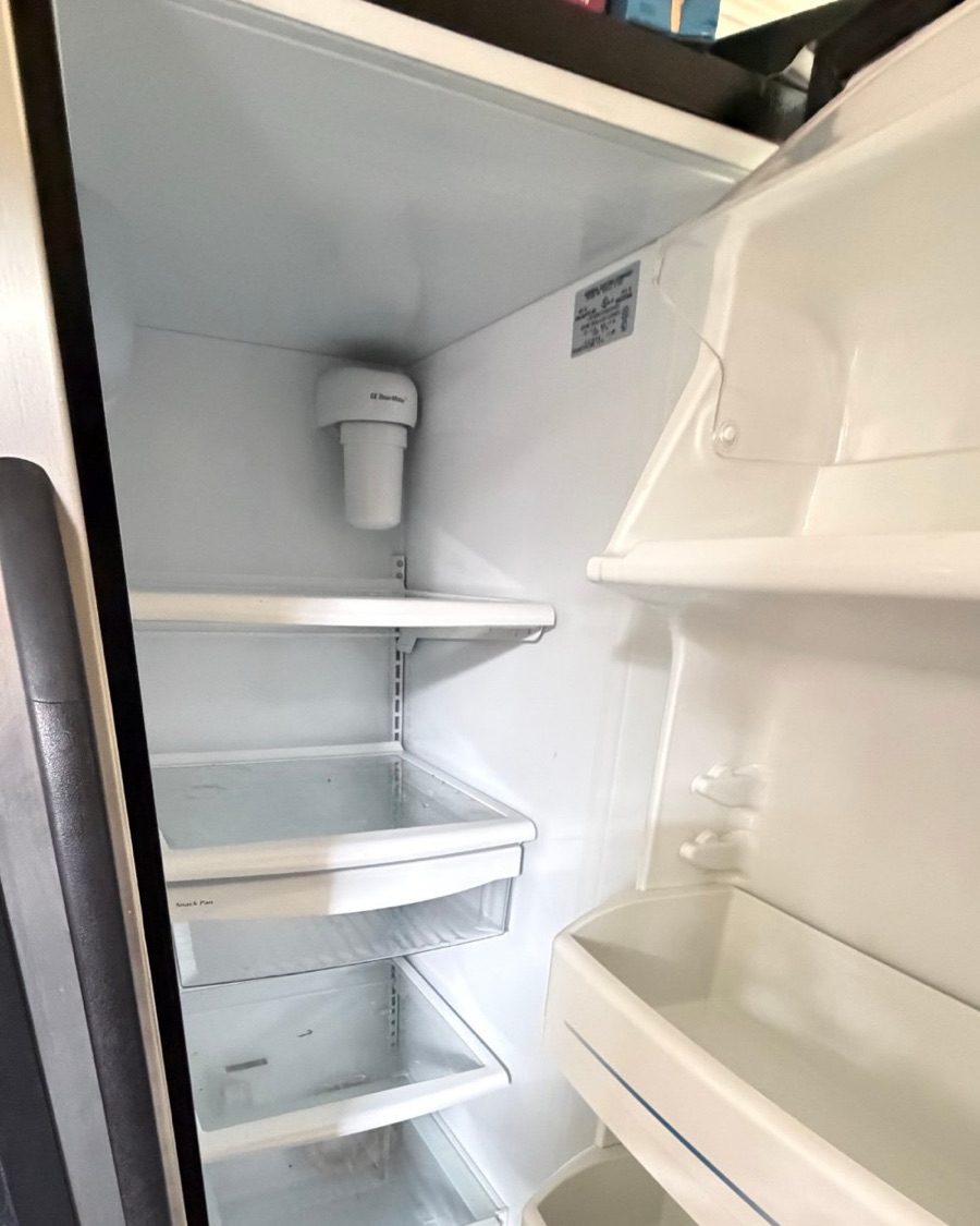Empty side-by-side refrigerator with the interior lights out because of a failed main control board